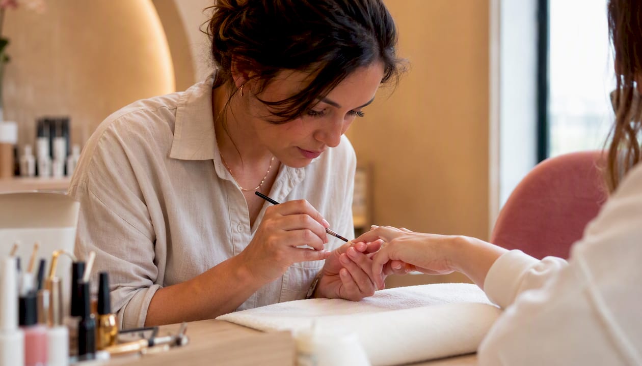 Technician fixing nail polish flaw