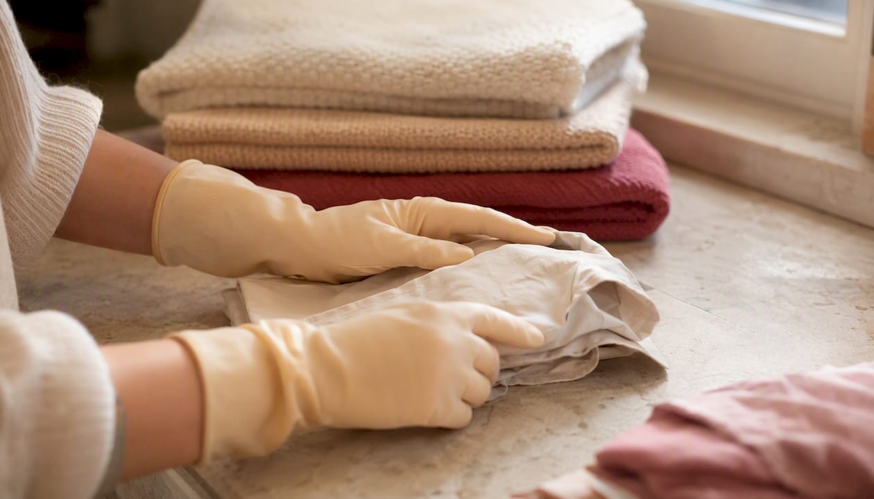 Hands wearing gloves washing dishes protecting manicure