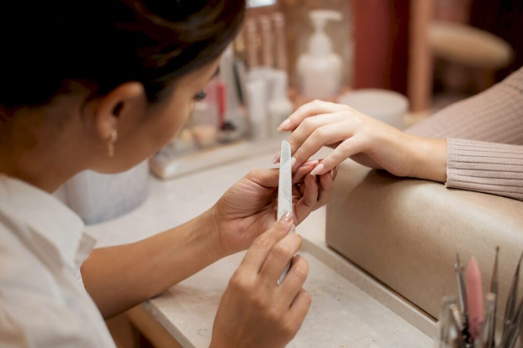 Close-up of nail technician filing nails