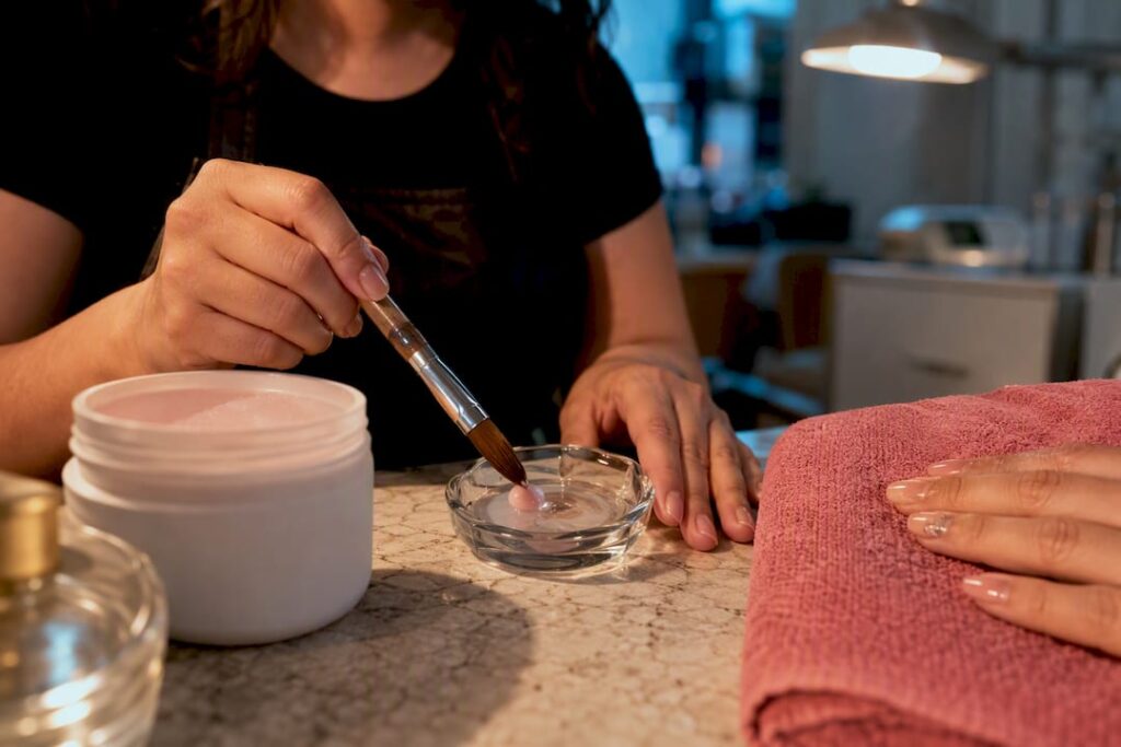 Technician mixing acrylic nail enhancement materials