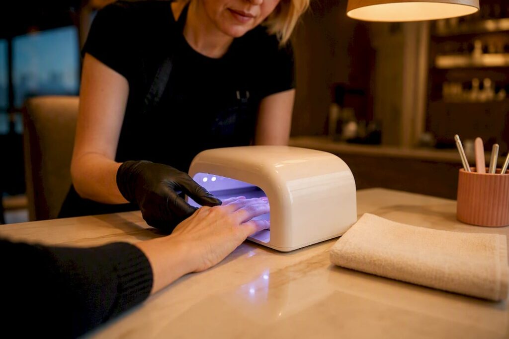 Gel manicure curing beneath salon lamp