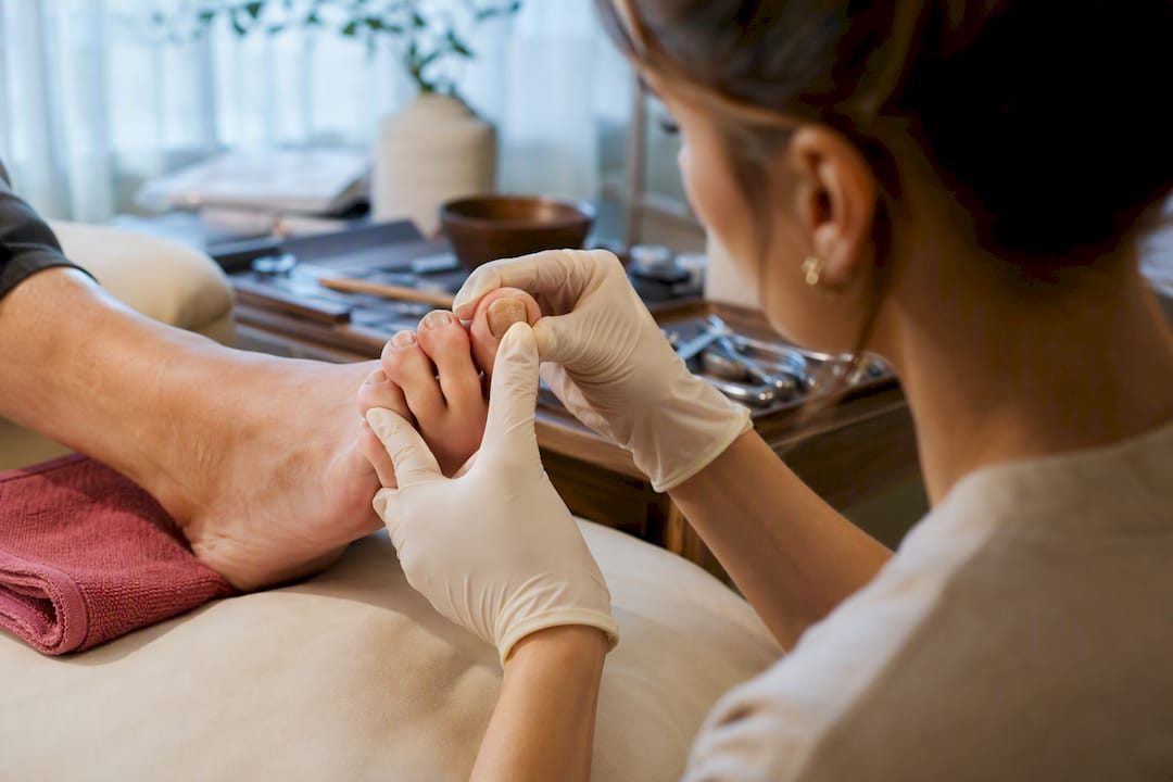 Technician checking thickened toenail