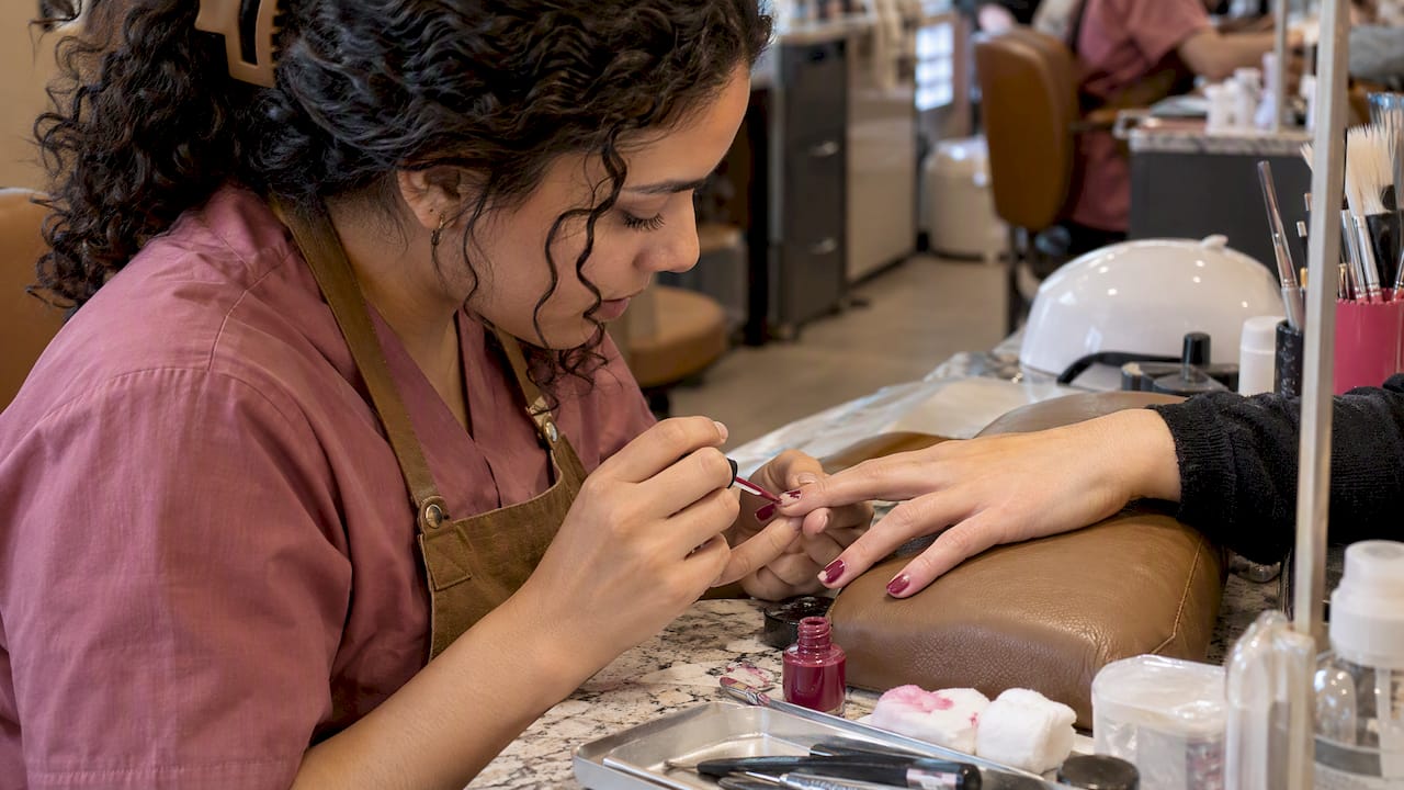 Technician correcting chipped salon polish